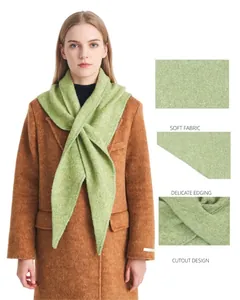 Detail view of light green wool knit triangular scarf with cutout design