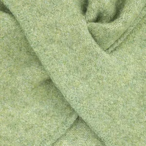 Close-up macro view of light green wool knitted scarf showing soft fiber texture