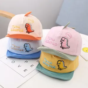 Detail view of colorful baby baseball caps with cute dinosaur embroidery and soft cotton fabric