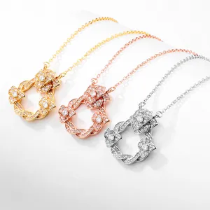 Trois colliers camélia en or, or rose et argent avec pavé de zircons cubiques.