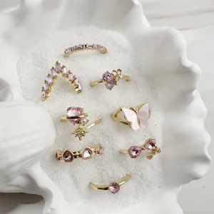 Detailed view of 9-piece gold-toned ring set featuring pink butterfly and heart motifs