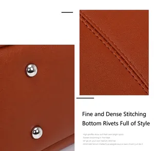 Detailed close-up showing fine stitching and silver rivets on brown leather handbag