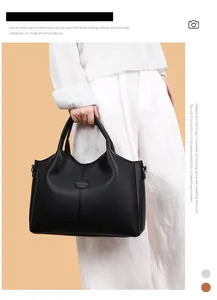 Close-up of a stylish large black vintage handbag held by a model for commuting