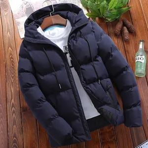 Close-up of a navy blue men's hooded puffer jacket styled on a rustic wood surface