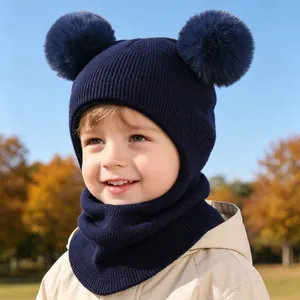 Close-up of navy blue children's winter knitted hood hat with double pom poms