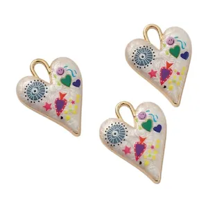 Close-up of hand-painted alloy heart pendants with colorful eye and star motifs for DIY