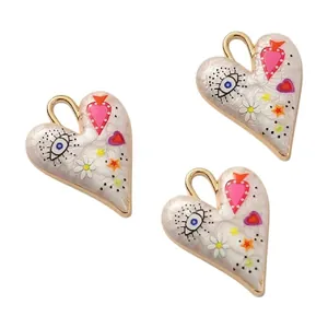Detailed view of hand-painted white enamel heart pendants for DIY jewelry making