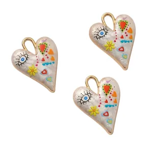 Detail of hand-painted alloy heart pendants with evil eye and floral motifs