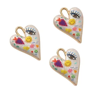 Detailed view of three hand-painted alloy heart charms with colorful patterns