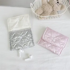 Detailed view of silver and pink quilted heart-pattern pouches with snap closure.