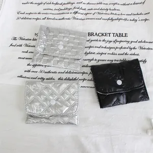 Close-up detail of stylish quilted PU coin purses and storage bags in silver and black