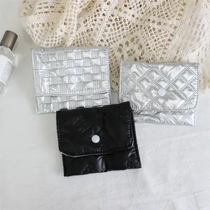Top-down view of silver and black quilted PU leather pouches with snap button