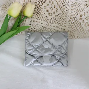 Close-up of a silver metallic quilted PU leather small coin purse with snap button