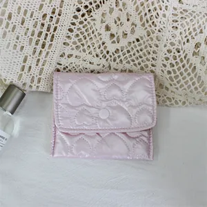 Detail view of a pink heart-quilted mini pouch for organizing coins and small cosmetics