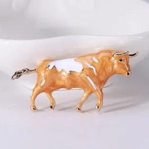 Broche élégante en forme de taureau avec émail marbré orange et une finition dorée