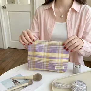 Close-up detail of the stylish purple and yellow plaid cosmetic bag with Sozakka label