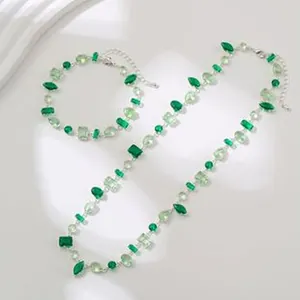 Detailansicht eines eleganten Sets aus Halskette und Armband mit grünen Zirkoniasteinen.