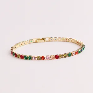 Farbenfrohes Regenbogen-Zirkonia-Tennisarmband in Gold-Finish auf rosa Hintergrund