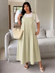 Detailed view of women's plus size light green solid color overall dress with ties