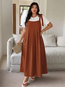 Detailed view of rust brown plus-size pinafore maxi dress with white t-shirt outfit