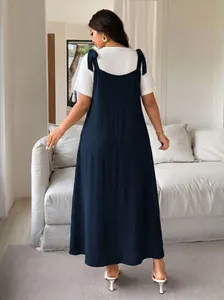 Back view of a plus size navy blue strappy maxi dress with white t-shirt styling