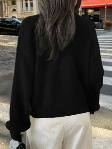 Pull en maille noir minimaliste décontracté pour femmes dans un décor de rue urbain