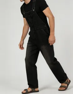 A detailed side view of men's vintage black denim overalls with adjustable straps