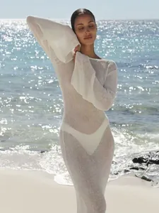 Vollansicht eines eleganten weißen Strick-Strandkleids an einer sonnigen Küste