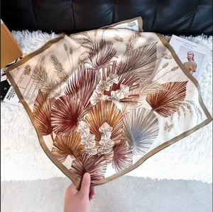 Elegante foulard quadrato in seta con una sofisticata stampa di foglie marroni e farfalle.