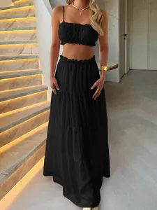 Two-piece black summer set featuring a ruffled crop top and tiered maxi skirt
