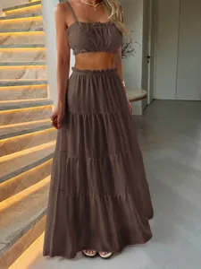 Detailed view of brown ruffle crop top and tiered maxi skirt set for summer
