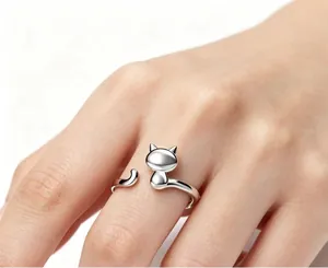 Close-up detail of a cute silver cat-shaped open ring being worn on a female finger
