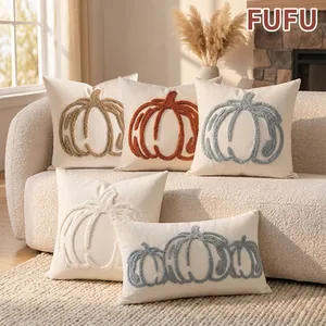 Detail macro view of pumpkin embroidered decorative pillowcases on a soft white sofa