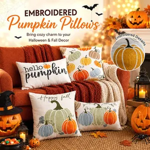 Embroidered detail view of festive pumpkin patterns on linen pillowcases.