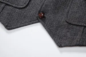 Detailed view of grey herringbone fabric and textured brown button on a vintage men's vest