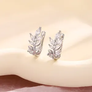 Detailed macro view of silver leaf ear clips adorned with sparkling marquise zircons.