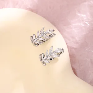 Detailed view of silver wheat leaf ear cuffs decorated with sparkling marquise zircons.