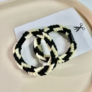 Detailed macro view of black and white braided twist rope hair ties for stylish hair styling