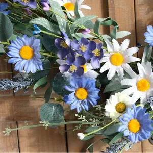Primo piano dettagliato di margherite artificiali blu e bianche su una ghirlanda