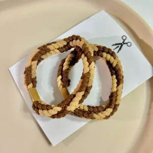 Close-up detail of coffee and beige braided hair ropes displayed on a decorative tray