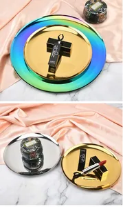 Detailed shot of gold and silver stainless steel round trays on pink silk fabric
