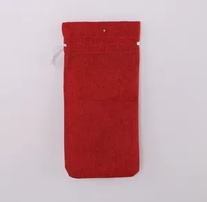 Detailed back view of a red burlap drawstring wine bottle bag for Christmas table decor