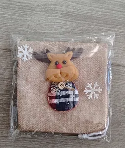Close-up of a Christmas burlap gift bag featuring a cute 3D reindeer doll and snowflakes
