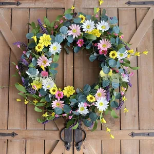 Bellissima ghirlanda di fiori primaverili con margherite colorate ed eucalipto su porta in legno