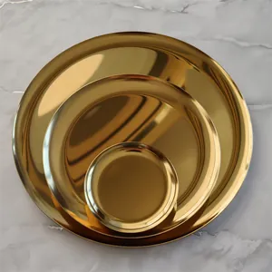 Set of three Nordic golden round metal trays in various sizes on marble
