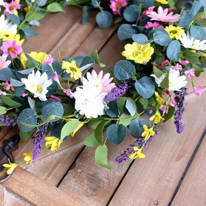 Primo piano di una vivace ghirlanda di fiori finti primaverili con margherite ed eucalipto