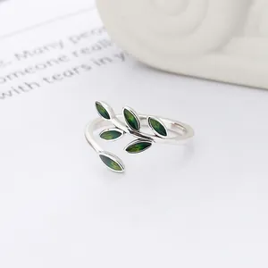 Detailed macro view of a 925 silver ring featuring delicate green enamel leaves