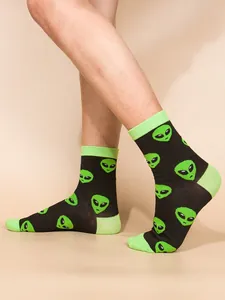 Macro detail showing the vibrant green alien pattern on comfortable black crew socks.