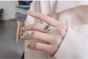 Macro detail of an adjustable 925 silver ring featuring vibrant green enamel leaf design
