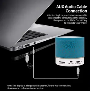 Detailed view of cracked pattern mini Bluetooth speaker showing AUX connection to laptop